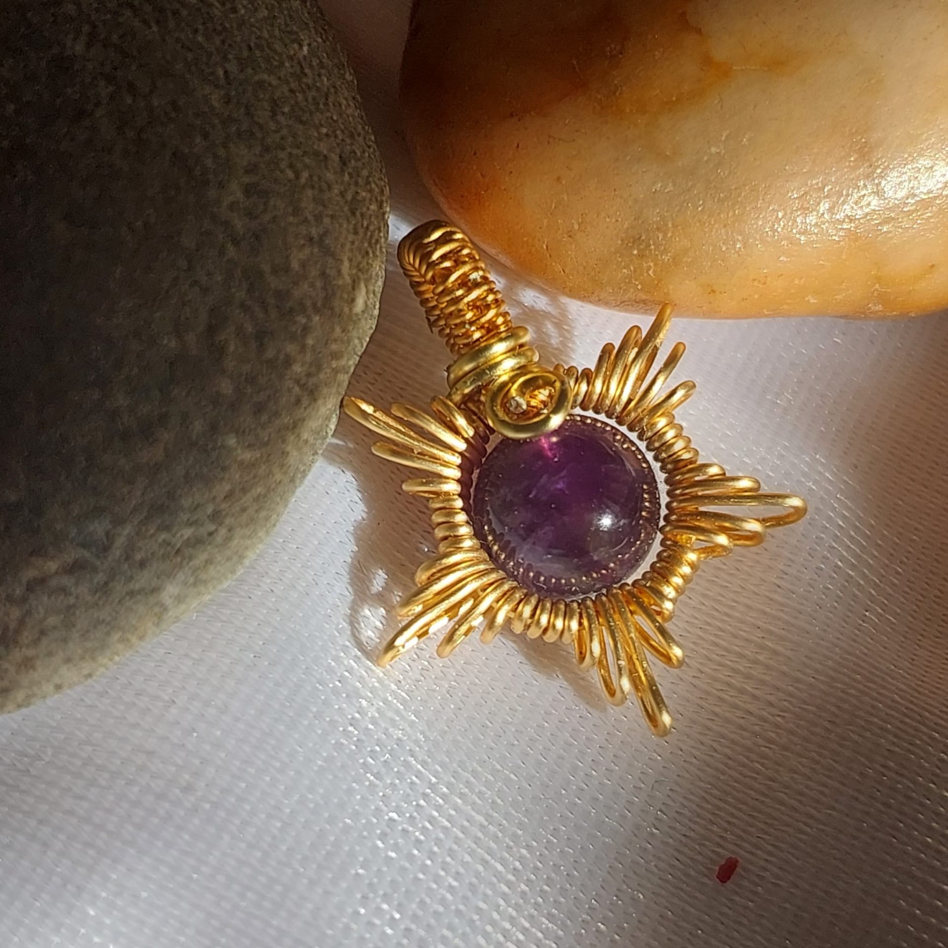 Handcrafted gold wire-wrapped pendant with amethyst gemstone center